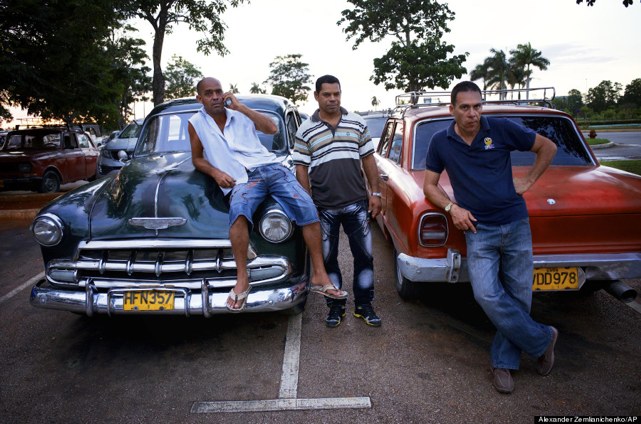 Drivers relax at their American classic cars at the Jose Marti international airport in Havana, Cuba, Tuesday, June 25, 2013. (AP Photo/Alexander Zemlianichenko)